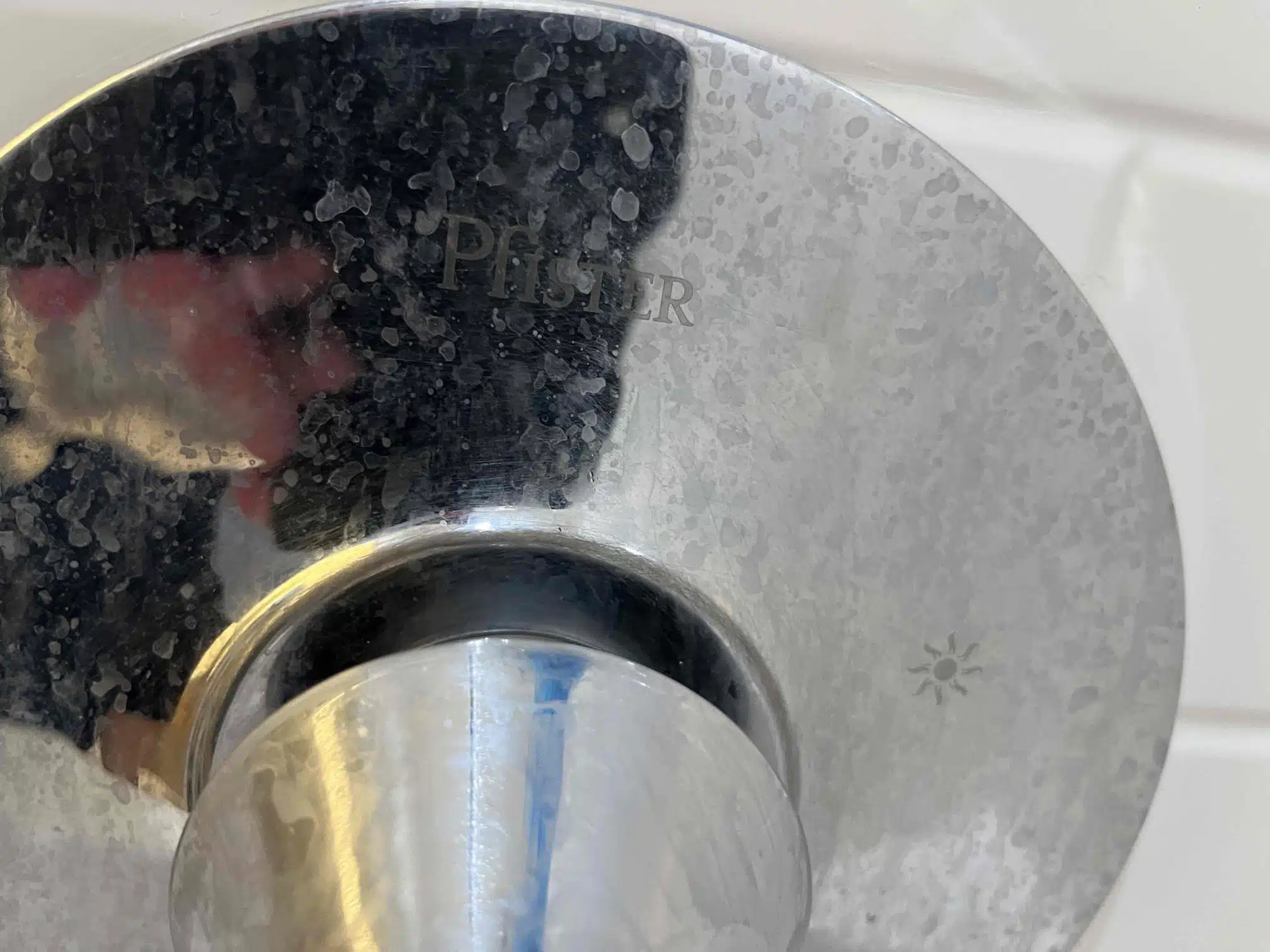 Hard Water Spots on Shower Fixture Hard water spots and mineral buildup on a shower fixture