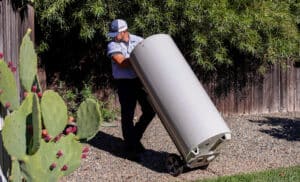 Technician removing an old water heater during a replacement service in Chico CA
