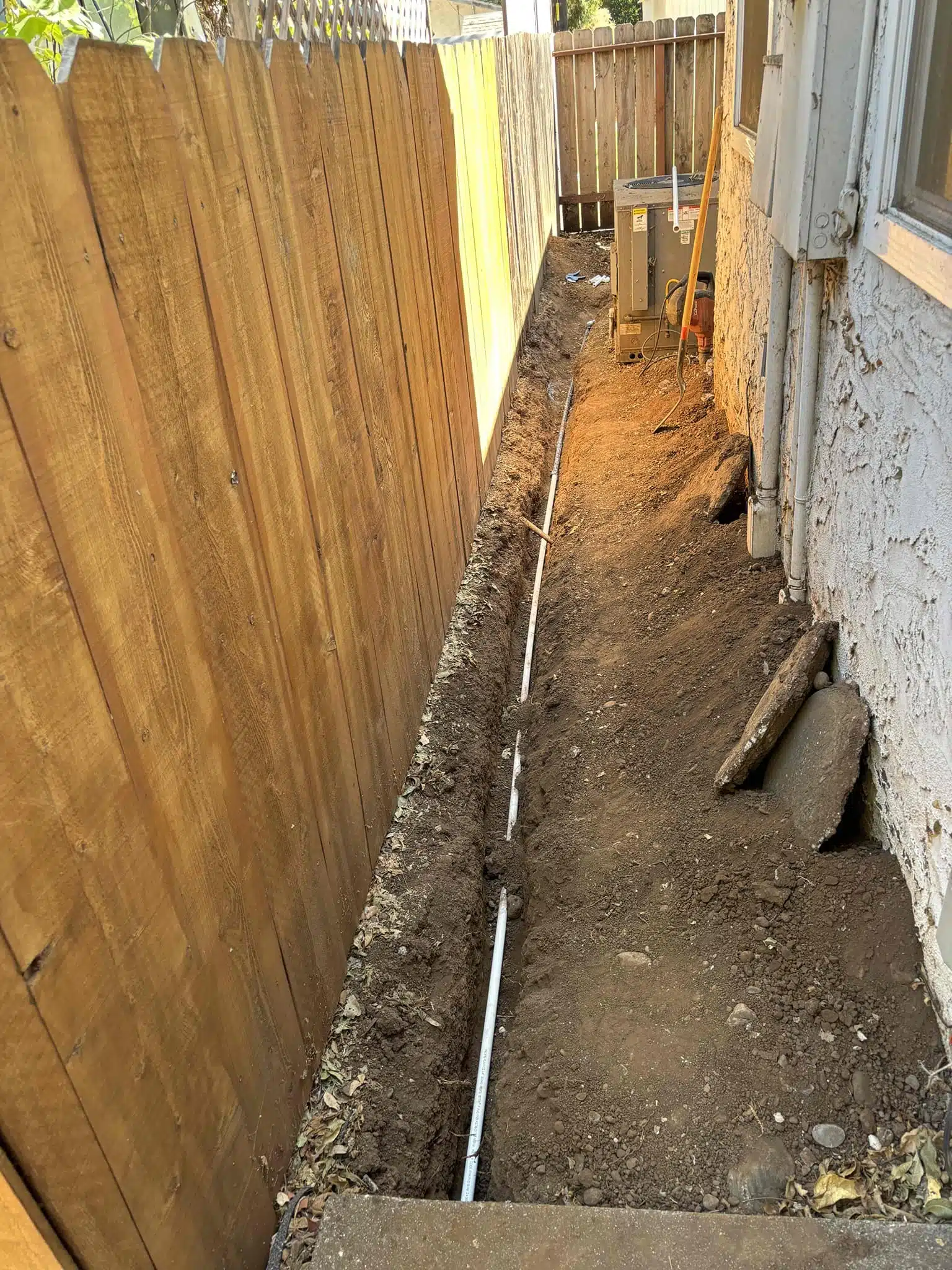 Side Yard Water Line Replacement During Installation Side yard water line replacement with new pipe installed in trench