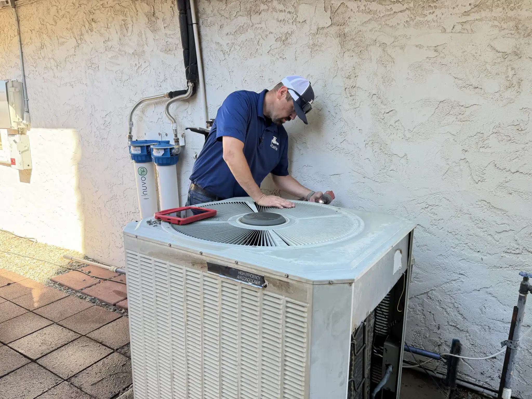Earl's Plumbing technician performing outdoor AC condenser maintenance in Chico CA